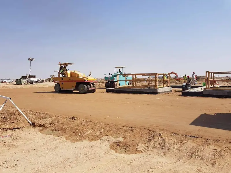 Rollers and graders working on a levelled desert site