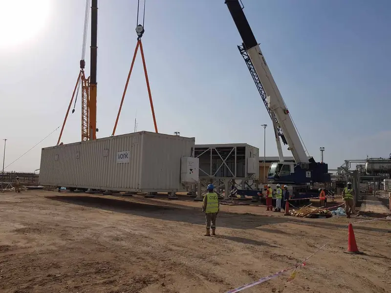 Crane lifting a site cabin on a project site