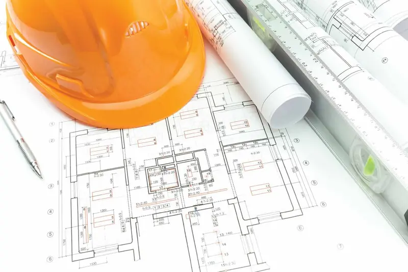 Architectural drawings with a hard hat on a desk